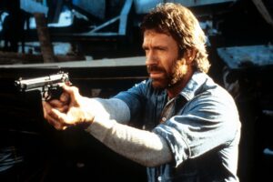 Chuck Norris points a gun in a scene from the film 'Hero And The Terror', 1988. (Photo by Cannon/Getty Images)